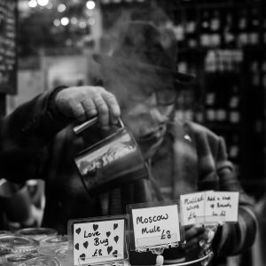 An elderly gentleman pouring a steaming drink