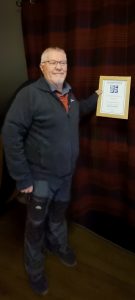 Neil displays the "Roll of Honour" award from the SCPF